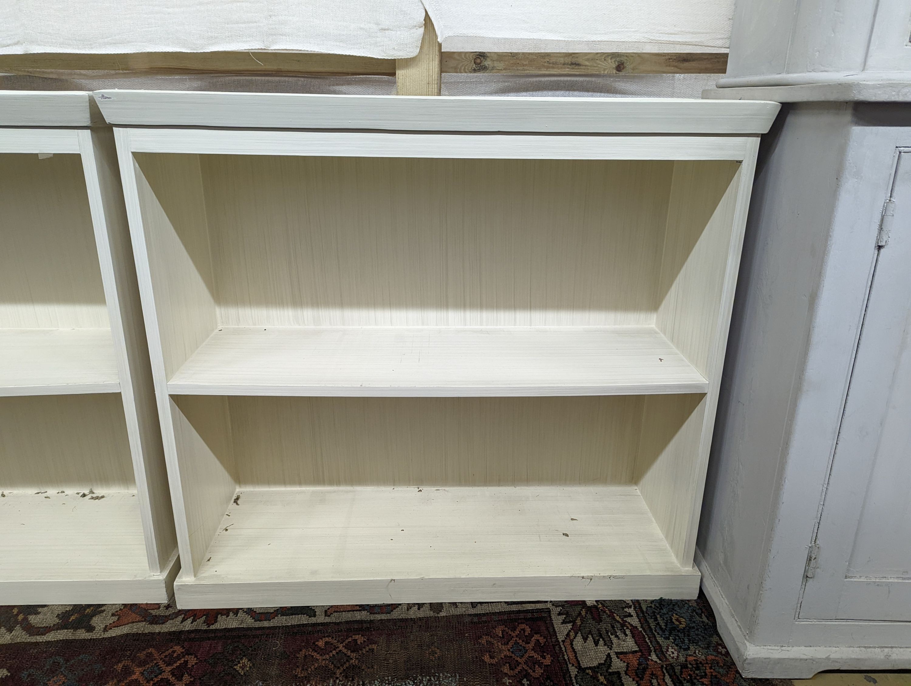 A pair of modern white painted dwarf open bookcases, length 90cm, depth 30cm, height 82cm